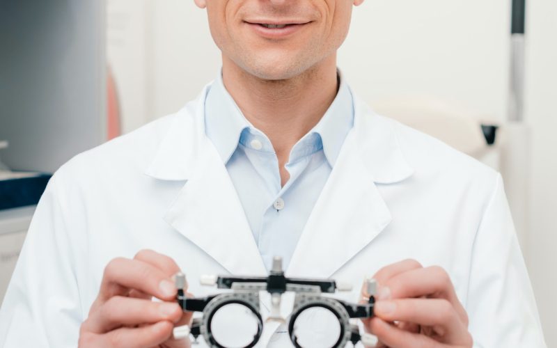 portrait-of-optometrist-in-white-coat-holding-trial-frame-in-hands-in-clinic.jpg