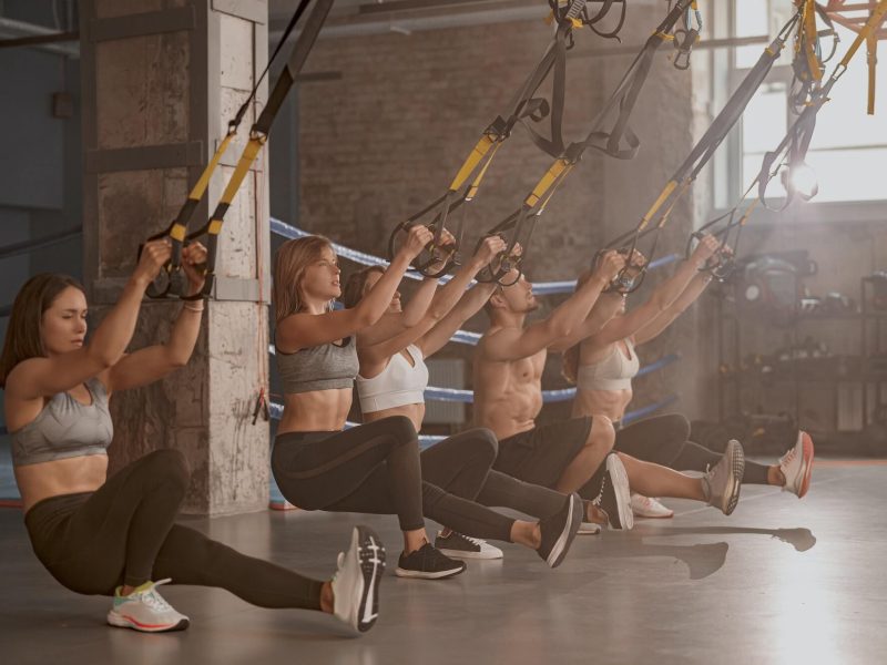 group-of-young-fitness-people-using-fitness-straps-in-sports-club-1.jpg