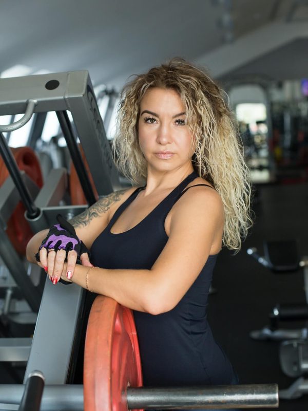 woman-with-long-blonde-curly-hair-portrait-of-a-fitness-trainer-in-the-gym-sports-form-1.jpg