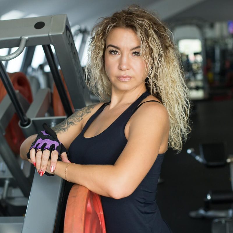woman-with-long-blonde-curly-hair-portrait-of-a-fitness-trainer-in-the-gym-sports-form-1.jpg